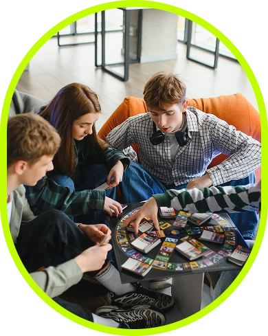 Un gruppo di amici che gioca a un gioco da tavolo moderno al chiuso, seduti su comodi divani, godendosi la strategia, il lavoro di squadra e l’intrattenimento sociale.
